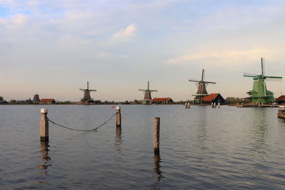 Picturesque scene of traditional Dutch windmills along the waterside at Zaanse Schans, Netherlands.