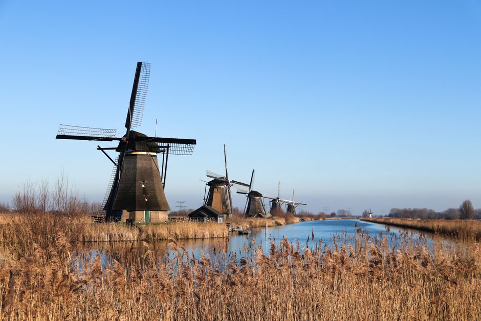 Scenic view of historic windmills along a canal in Kinderdijk, Netherlands.
