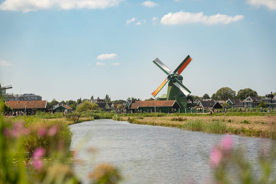 Beautiful view of traditional windmill and river in Zaandam, Netherlands on a summer day.